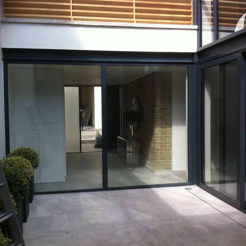 Floor-to-ceiling sliding doors opening to courtyard in East Molesey