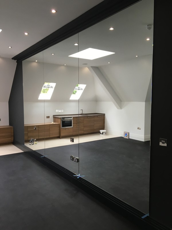 Frameless glass partition in loft conversion by East Molesey glaziers